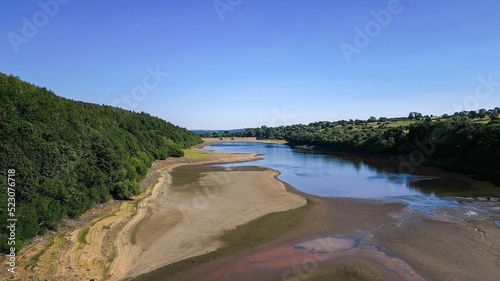 Drone footage of aerial view over Lindley Wood Reservoir, North Yorkshire, during drought in summer 2022 heatwave. Empty reservoir basin shows cracked dry bare ground.