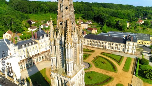 Aerial View Of Notre Dame De Montligeon Church In Town By Green Trees - La Chapelle-Montligeon, France photo