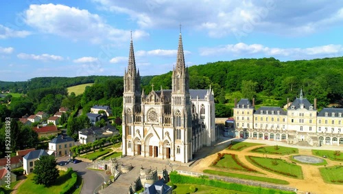 Aerial Forward Shot Of Notre Dame De Montligeon Church Amidst Houses In Town - La Chapelle-Montligeon, France photo