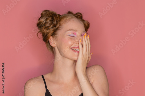 Beautiful red haired woman smiling and flirting sexually looking with surprise and awe to the side dressed in summer clothes and on isolated background