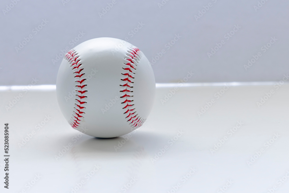 An isolated baseball on a white background and table An isolated baseball on a white background and table