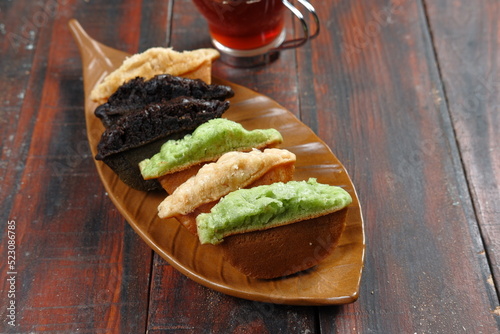 Kue Pukis, Traditional Javanese half-moon shaped pancakes. made from flour eggs yeast and coconut milk.on wooden background photo