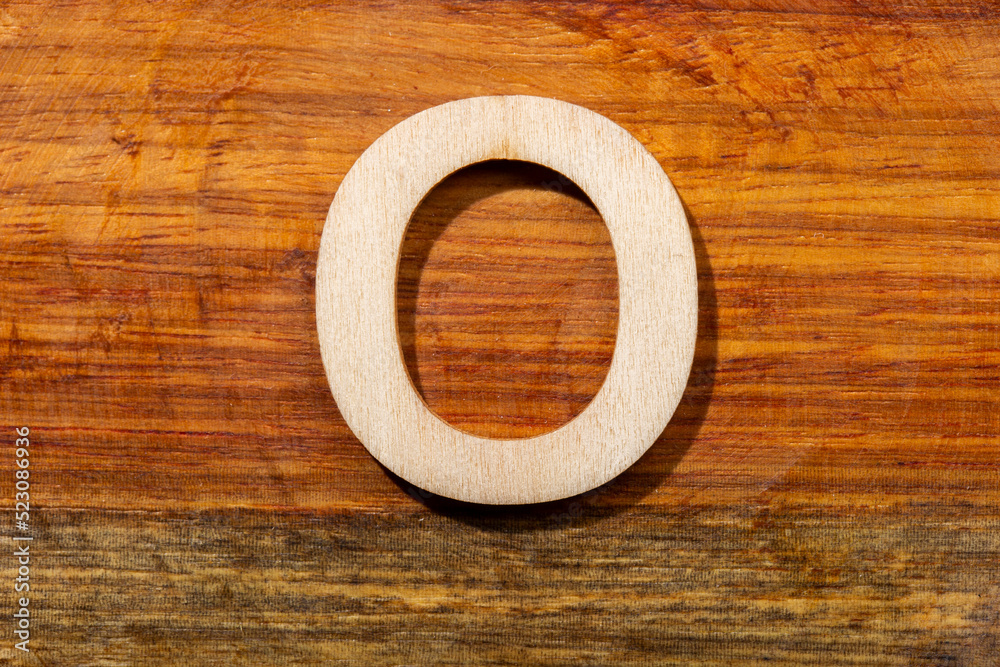 Wooden letters O on wooden background, top view Wooden letters O on wooden background, top view