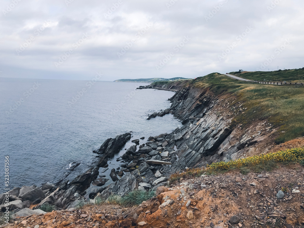 Ocean view and cliffs off Cape Breton, Nova Scotia. Cabot Trail visible in the background