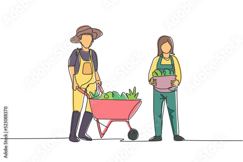 Single continuous line drawing happy couple farmer with wheelbarow trolley and basket full of fruits. A successful harvest activity minimalism concept. One line draw graphic design vector illustration