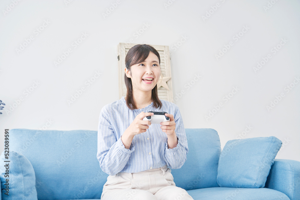 自宅で一人でテレビゲームをする女性 自宅で一人でテレビゲームをする女性