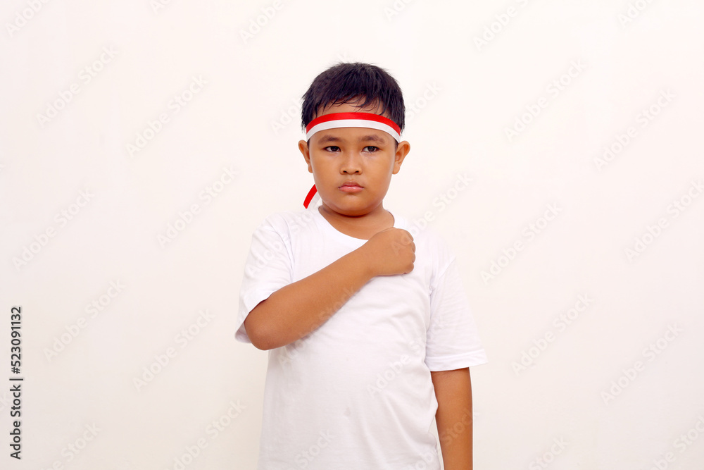 Asian boy standing with respect or salute gesture. Indonesian independence day concept Asian boy standing with respect or salute gesture. Indonesian independence day concept