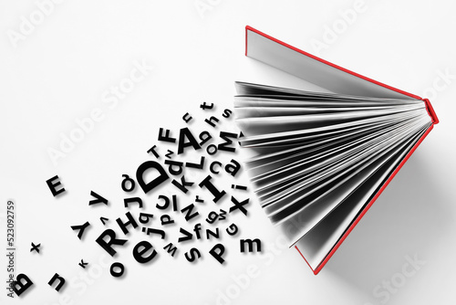 Open book with letters on white background, top view. Dyslexia concept photo