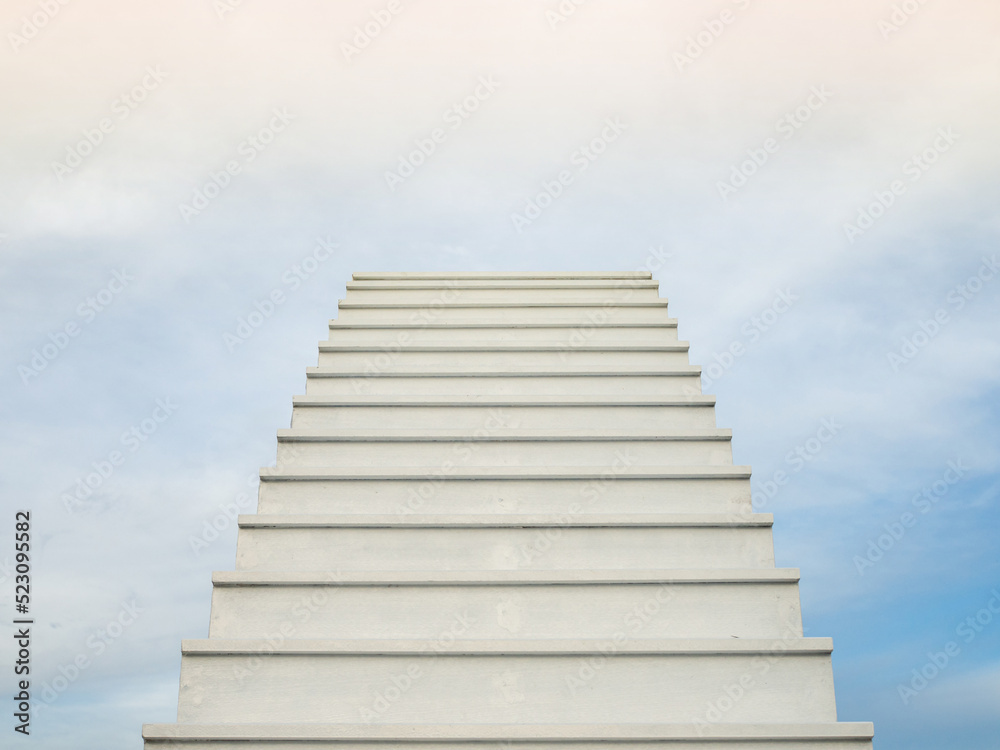A white staircase stretches up the horizon. That means to be success or go to heaven.