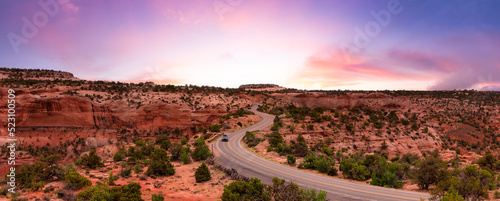 Scenic Road surrounded by Red Rock Mountains in the Desert. Colorful Sunset Sky Art Render. Canyonlands National Park. Utah, United States. Adventure Travel. Panorama