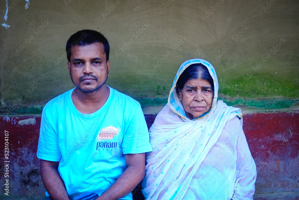 Bangladeshi hindu religious son with his elderly mother, south asian family in village environment