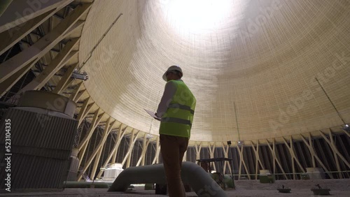 Oil refinery.
Inside of cooling tower located inside oil refinery and engineer working.
