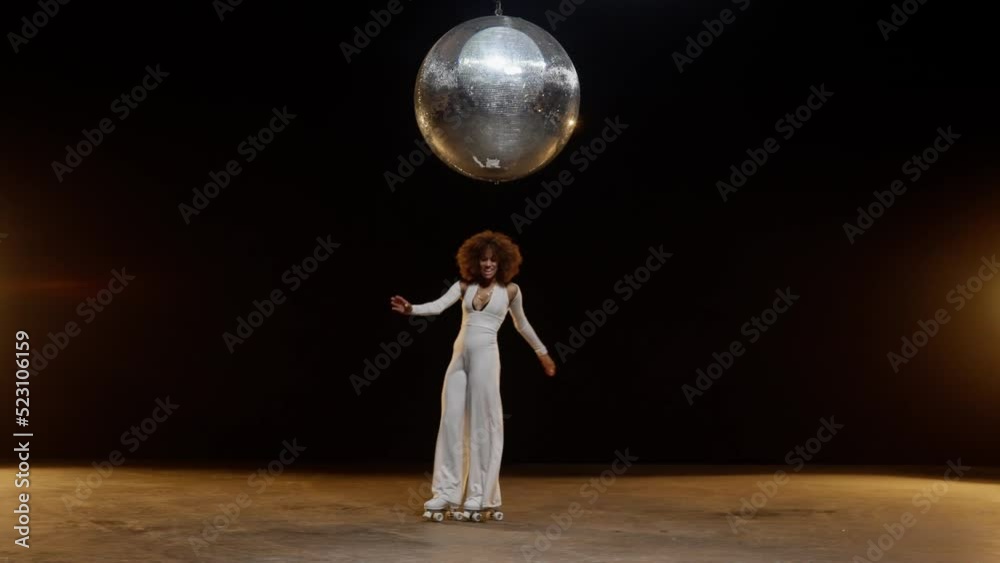 Charming African American Woman in Roller Skates Rides Around Under Disco Ball