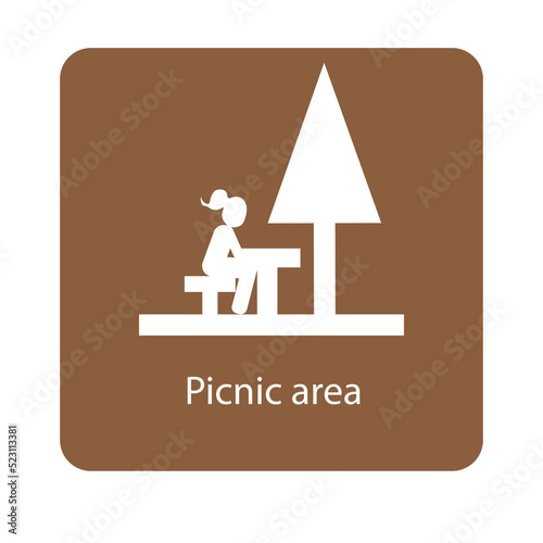 Picnic area sign with a girl sitting on a picnic table under a tree