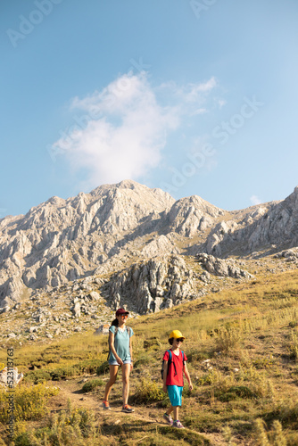 mother with a child on a hike walk along the road © zhukovvvlad