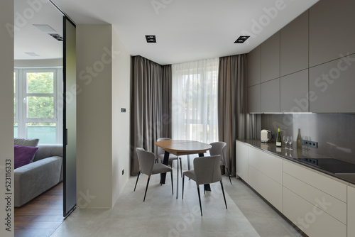 modern kitchen interior, kitchen with dining table in modern style, large modern kitchen in beige brown tones © Serhii Savchenko