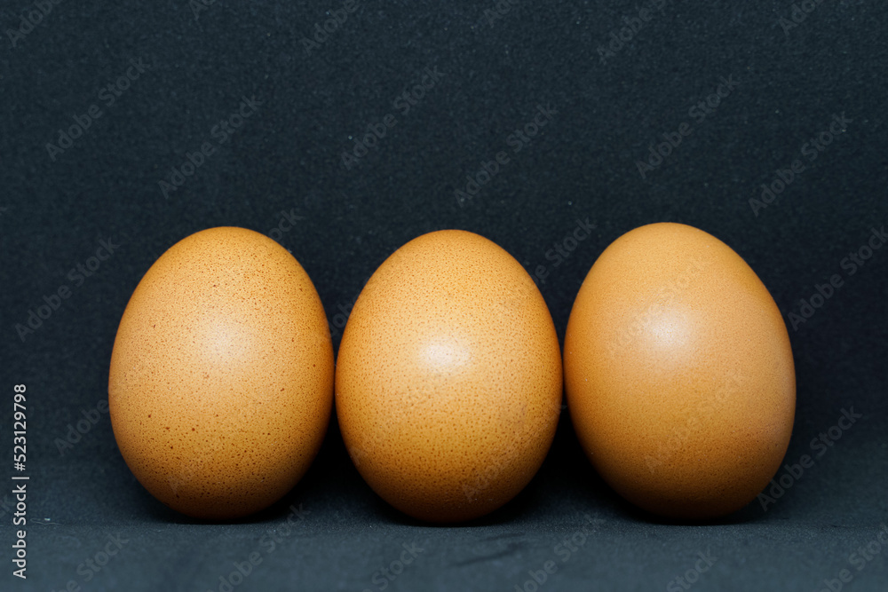 fresh chicken eggs laid out on a black background. fresh chicken eggs laid out on a black background.
