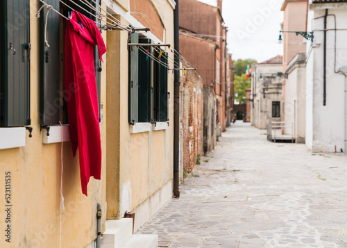 Red garment hung to dry outside a window in Venice, Italy © gammaphotostudio