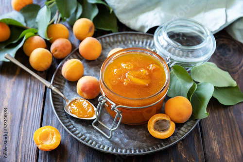 Homemade preservation. Delicious apricots jam or jelly on a rustic wooden table.