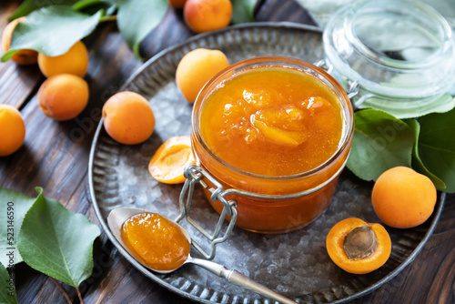 Homemade preservation. Delicious apricots jam or jelly on a rustic wooden table.