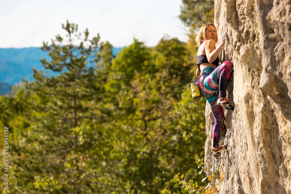 The girl climbs the rock.