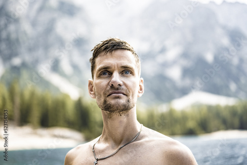 Young shirtless man with visionary view at Baires Lake in the Dolomite mountains in the afternoon. Braies Lake (Pragser Wildsee, Lago di Braies), Dolomites, South Tirol, Italy, Europe. photo