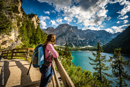 Young woman enjoys beautiful view on Baires Lake in the Dolomite mountains in the afternoon. Braies Lake (Pragser Wildsee, Lago di Braies), Dolomites, South Tirol, Italy, Europe. photo