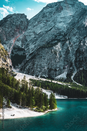 Fototapeta Naklejka Na Ścianę i Meble -  Beautiful view people staying at the shore of turquoise Baires Lake in the Dolomite mountains in the afternoon. Braies Lake (Pragser Wildsee, Lago di Braies), Dolomites, South Tirol, Italy, Europe.