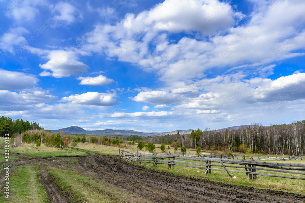 Fototapeta premium South Ural farm, wooden fence and arable land with a unique landscape, vegetation and diversity of nature.