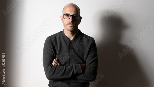 portrait of serious bald man dressed in dark gray tones, sober half-length portrait of a person.
