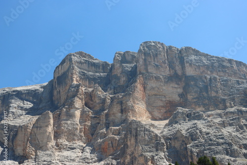 Val Badia, Italy-July 17, 2022: The italian Dolomites behind the small village of Corvara in summer days with beaitiful blue sky in the background. Green nature in the middle of the rocks. photo