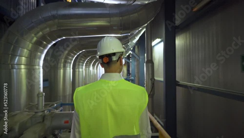 Senior engineer walking in factory.
The engineer who took the job security is walking inside the factory.
