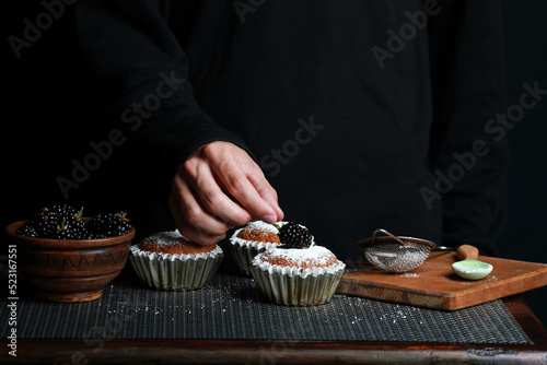 delicious cupcakes with blackberries and powdered sugar