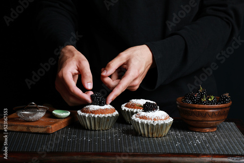 delicious cupcakes with blackberries and powdered sugar