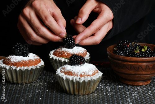 delicious cupcakes with blackberries and powdered sugar