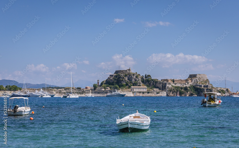Boat on Garitsa Bay in Corfu town on Corfu Island in Greece, Old Fortress on background