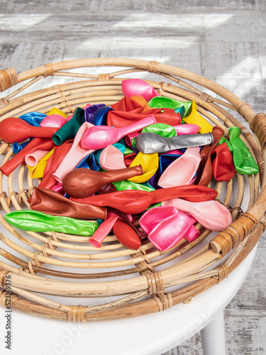 Group of colorful balloons on wooden background. Holiday goods. Non-inflated balloons