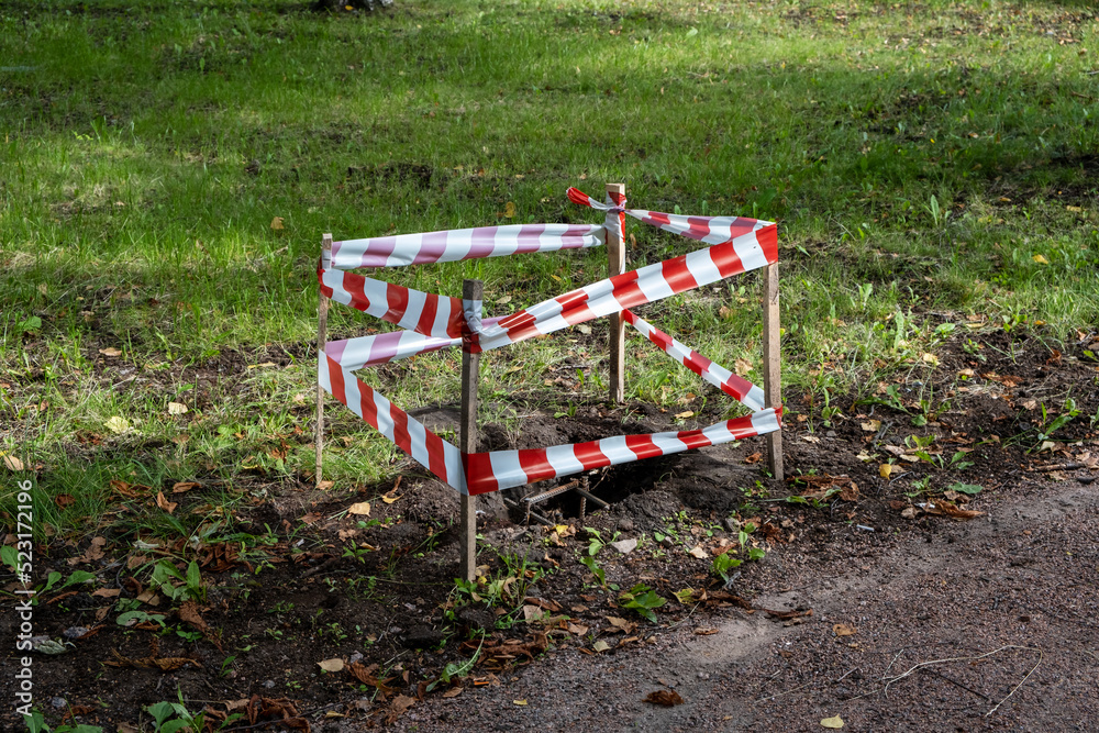 pit for tree seedlings, fenced with signal tape