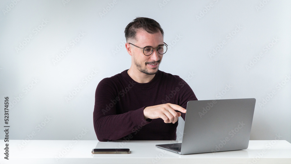 A man communicates via video call in a laptop at his desk A man communicates via video call in a laptop at his desk
