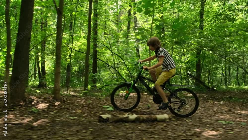 Cycling in forest. Child rides bike in park. Slow motion Cycling in forest. Child rides bike in park. Slow motion