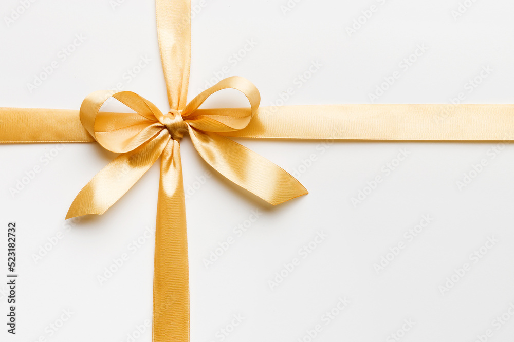 Top view of gold ribbon rolled and yellowbow isolated on colored background. Flat lay with copy space Top view of gold ribbon rolled and yellowbow isolated on colored background. Flat lay with copy space