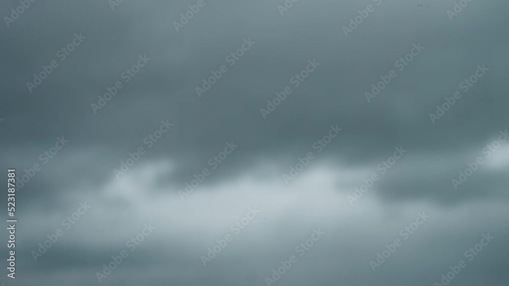 Slow motion raindrops on window glass with storm clouds on background Slow motion raindrops on window glass with storm clouds on background