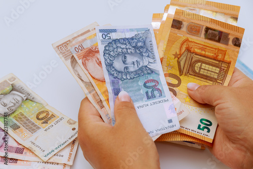 Euro and kunas of various denominations in the hands of a tourist on a white background. Currency of Croatia and Europe.