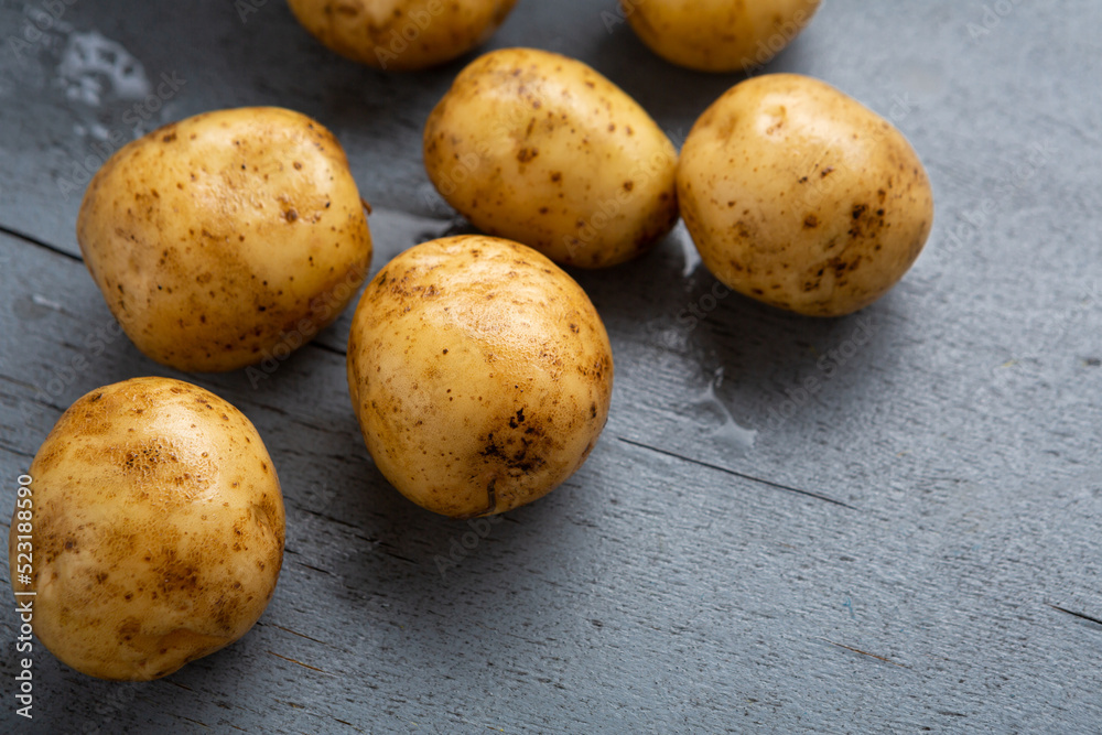 Raw potoes root on wooden surface cooking food
