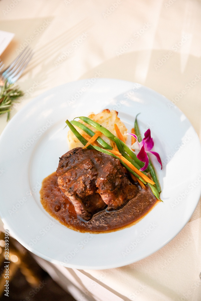 Gourmet plated steak dinner with floral garnish Gourmet plated steak dinner with floral garnish