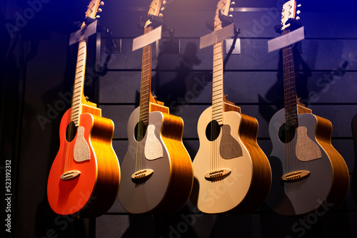 Selective focus to guitar in music shop, many guitars, pop rock artist song music and entertainment instrument.
