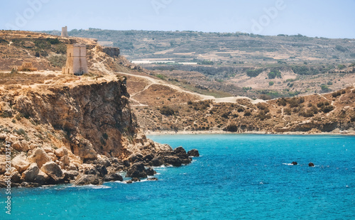 A view of the cliff and Ghajn Tuffieha Tower from Golden Bay in Mellieha, Malta photo