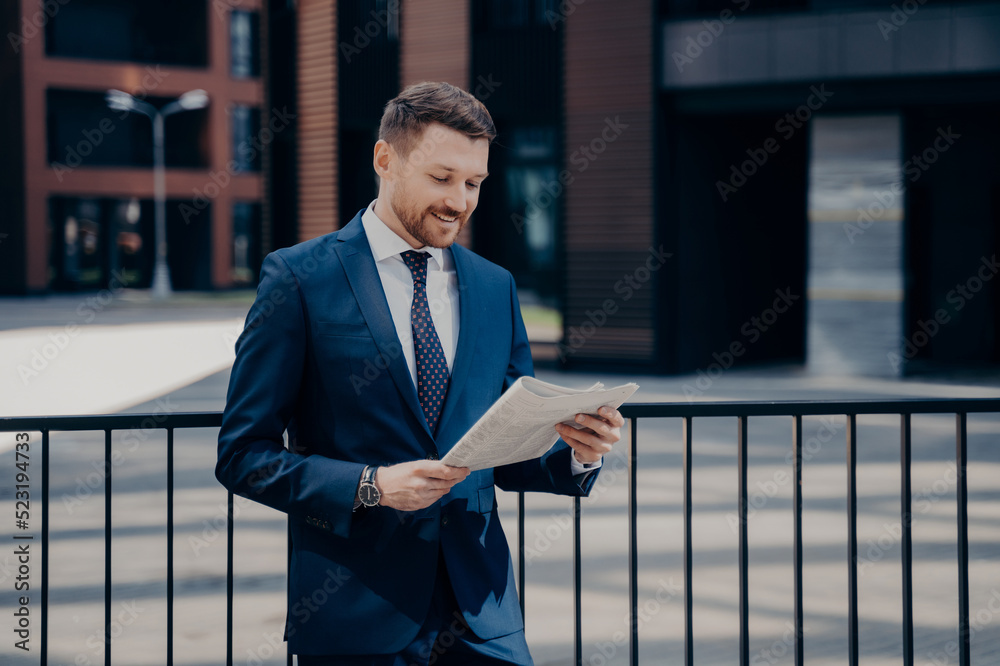 Trendy dressed businessman in stylish clothing reading business news outdoor Trendy dressed businessman in stylish clothing reading business news outdoor