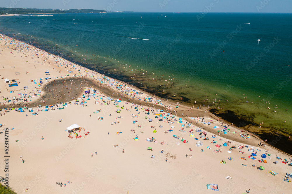 Baltic coast, people having bath in the sea and in the Oliwski stream mouth to the sea during hot summertime weekend