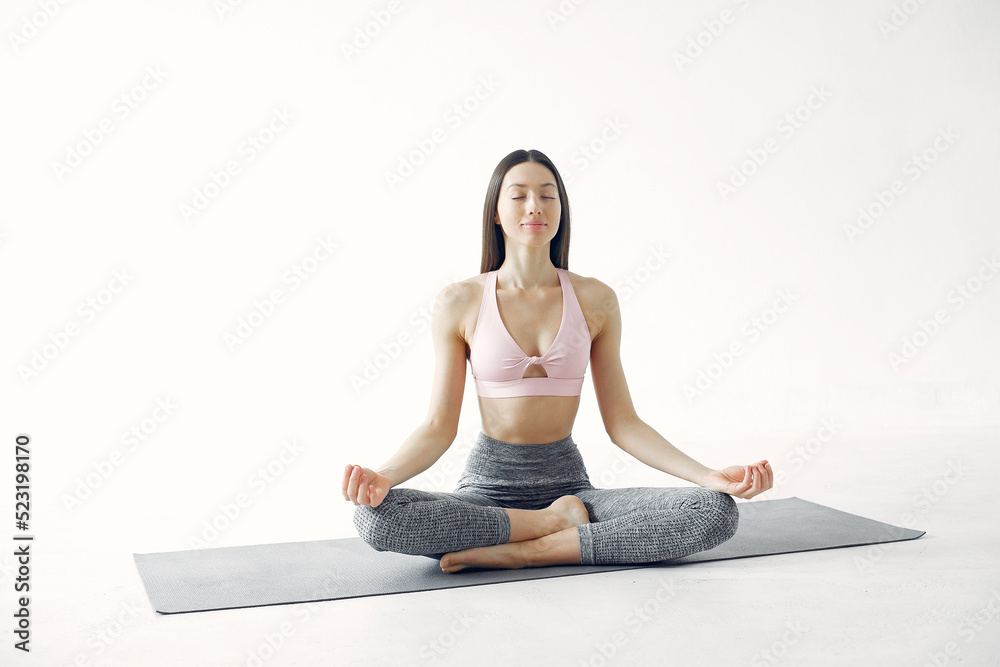 A beautiful girl is engaged in a yoga studio